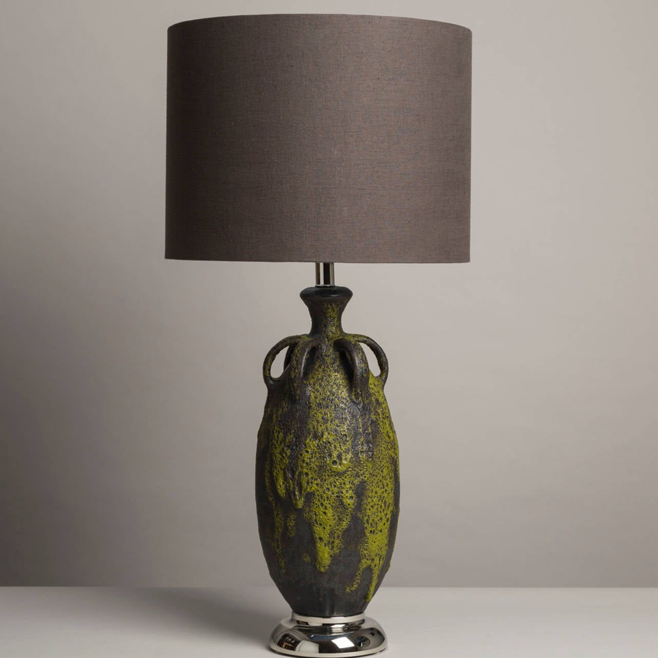 Large single black and lime green ceramic lava glazed table lamp with urn style handles 1950s accompanied with a linen lamp shade.
  