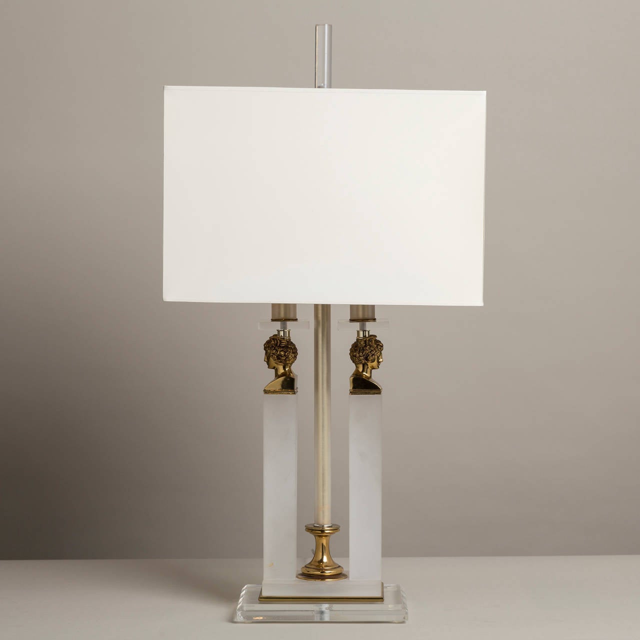 A single frosted and clear Lucite neoclassical style column table lamp with brass bust detailing, 1970s.
