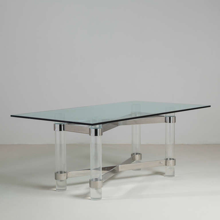 A Superb Lucite and Chromed Steel Based dining table with Glass Top, attributed to Karl Springer. Chunky Lucite column legs and Cross-Shaped Chromed construction with Bevelled Glass Top. Vintage condition. 