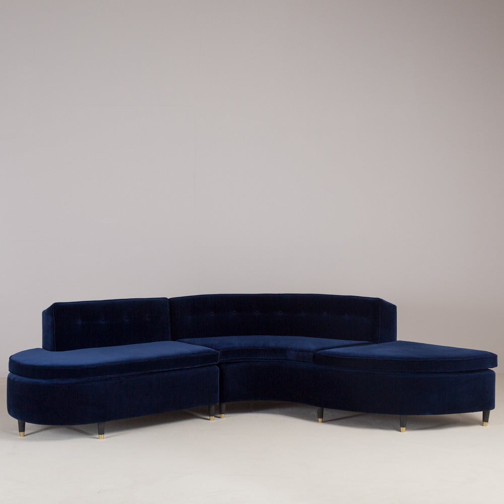 A standard two-part velvet upholstered buttoned back sectional sofa on ebonized legs by Talisman Bespoke.

This tailored sectional sofa is inspired by a sleek 1950s design with elegant ebonized wooden tapered legs. Available in a variety of