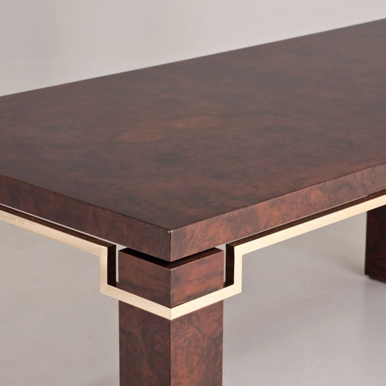 A walnut dining table designed by Pierre Cardin with brass metal detailing, 1980s.
