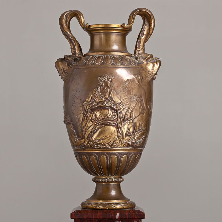 A French bronze urn depicting neoclassical women and lion adorned handles on a mottled burgundy marble base, circa 1860.

 