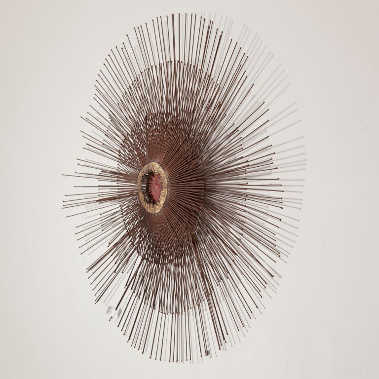 A Starburst Metal Wall Sculpture with Red Enameled Centre Detail