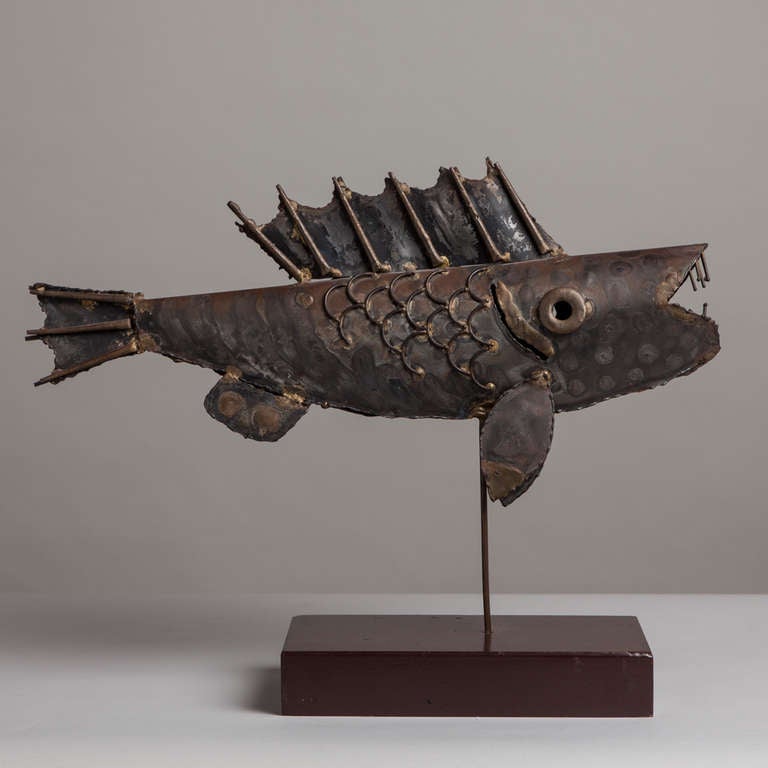 A Brutalist torch cut metal fish table sculpture mounted on a wooden base 1970s.

