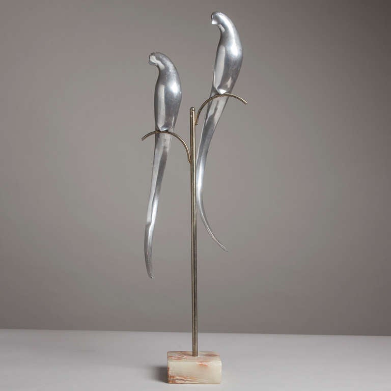 A pair of aluminium birds on a stand attributed to Curtis Jere mounted on a marble base.
