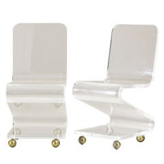 A Single Lucite Z-Shaped Chair on Brass Wheels