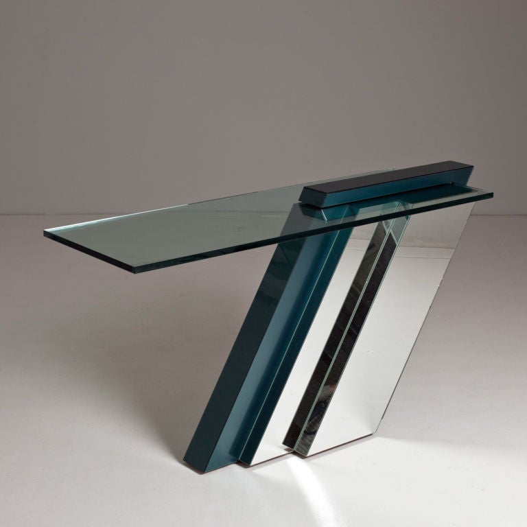 A cantilevered console table with a tiered mirrored and brushed blue base and glass top, 1980s.
