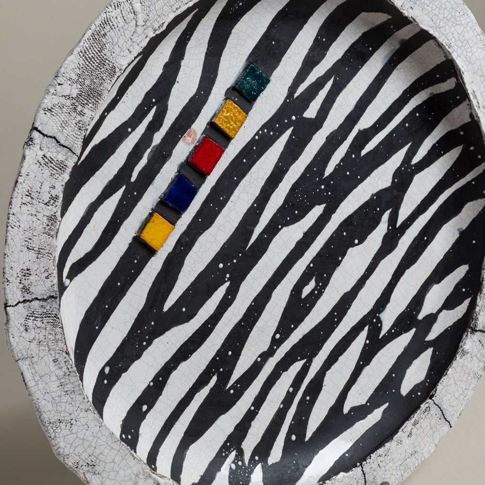 A large Catriona McLeod Zebra patterned raku fired ceramic plate signed 2008.

The raku fire method differs from other ceramics as the pieces are moved from the kiln whilst still glowing into a container to allow them to smoke creating an
