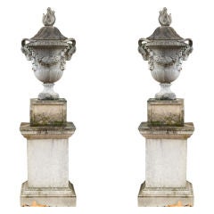 A Pair of Lidded Ramshead Urns with Grapevine Design