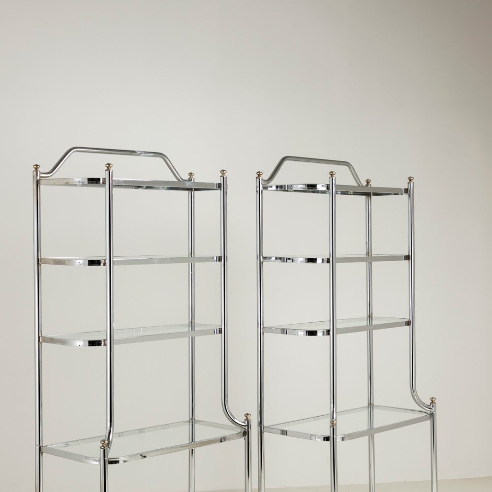 Pair of nickel framed Étagères with brass detailing on the uprights. The Étagères have five glass shelves where the top three are skinnier in depth due to the nickel curving out for the bottom two shelves making an very elegant looking pair of