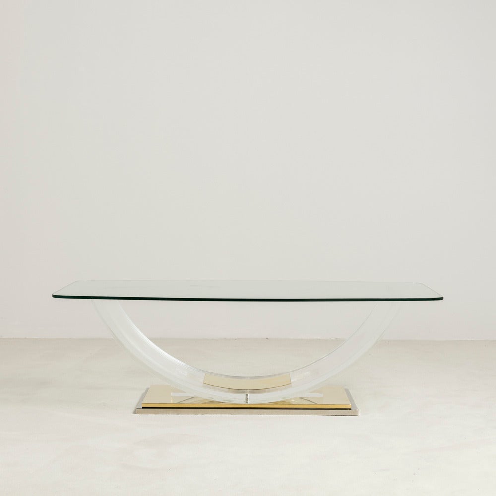 A sculptural polished brass and Lucite coffee table, 1970s

Glass top not included in the price.