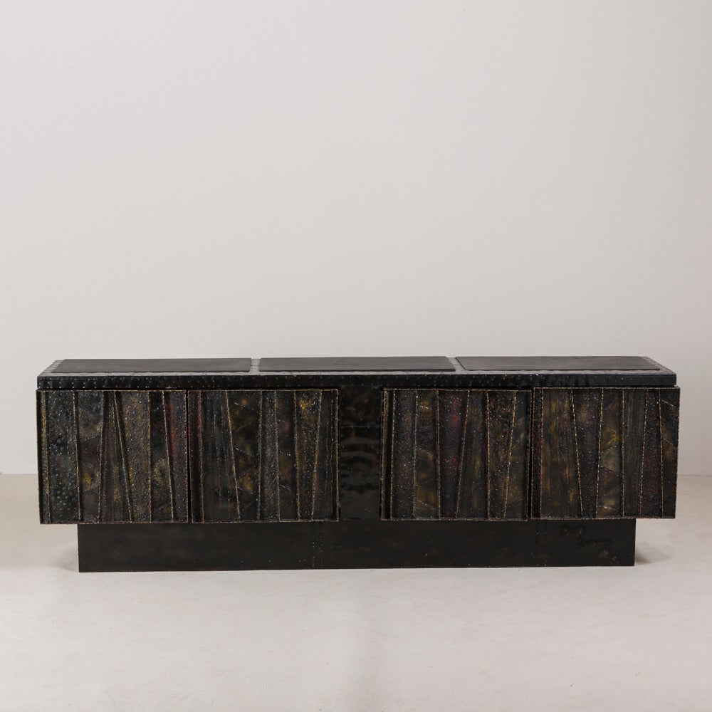 A large studio Paul Evans designed sculpted metal four-door cabinet with three part inset slate top USA signed and dated 1968.