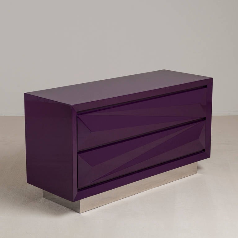 A standard purple lacquered asymmetrical two-drawer commode on steel base by Talisman Bespoke. 

This simple faceted classic design is available in a wide range of lacquer colours (RAL/paint colours can be specified) with either a brass or steel