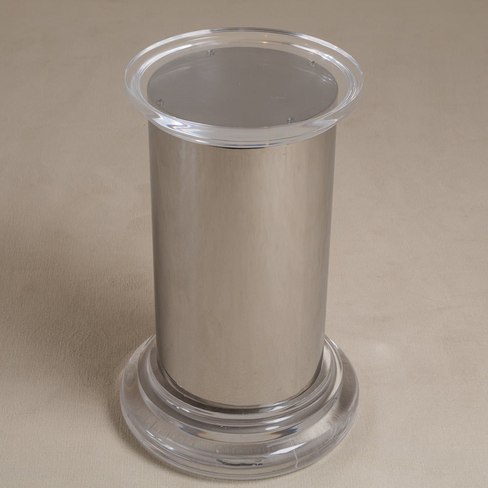 A cylindrical steel pedestal or table base set on a chunky Lucite base with a Lucite top, 1970s.

Measurements show diameter at base of pedestal. The diameter at the top of pedestal is 40cm.
 