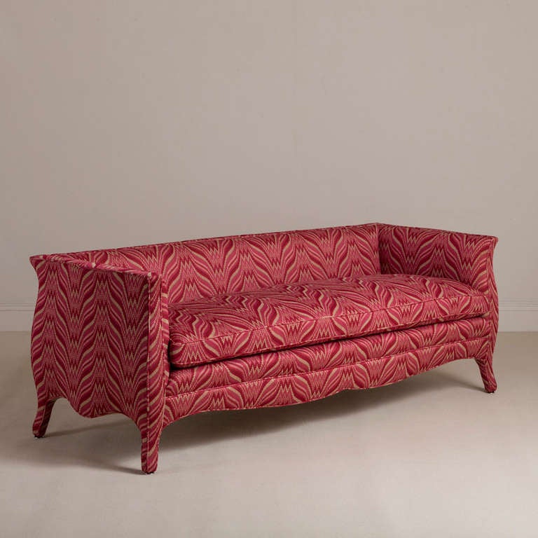 A standard high back French style Berry Rose upholstered sofa by Talisman Bespoke. Unusual and elegant, this signature Talisman Bespoke sofa is inspired by a unique French 20th century design. This sofa is available in a variety of fabrics and can