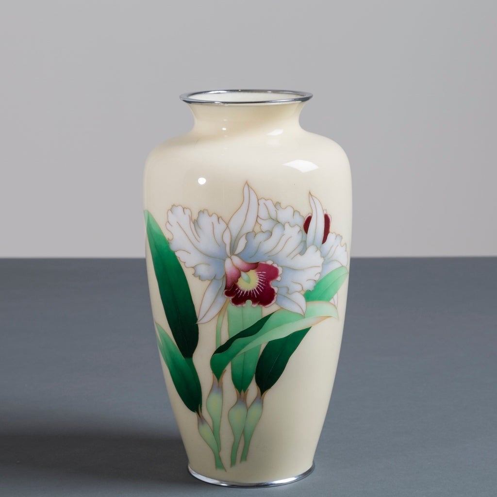 A Japanese cloisonne´ cream enamel vase depicting an orchid from the Showa period.
