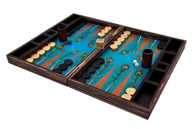 Inside – Zebrano backgammon board with a turquoise background and hand-painted feathers, finished with hand-applied lacquer.

Outside – Zebrano with brass sliding fastenings and hinges.

Playing pieces - Antique gold and black weighted aluminium