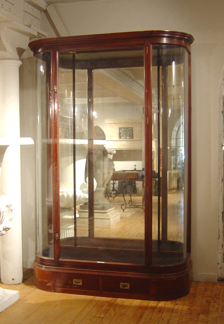 Rare English 19th Century, mahogany and glass display case with fabulous curved glass ends and a unique glass top which allows for natural light and a mirrored back, as well as adjustable glass shelves. Beautifully scaled with unique air-tight