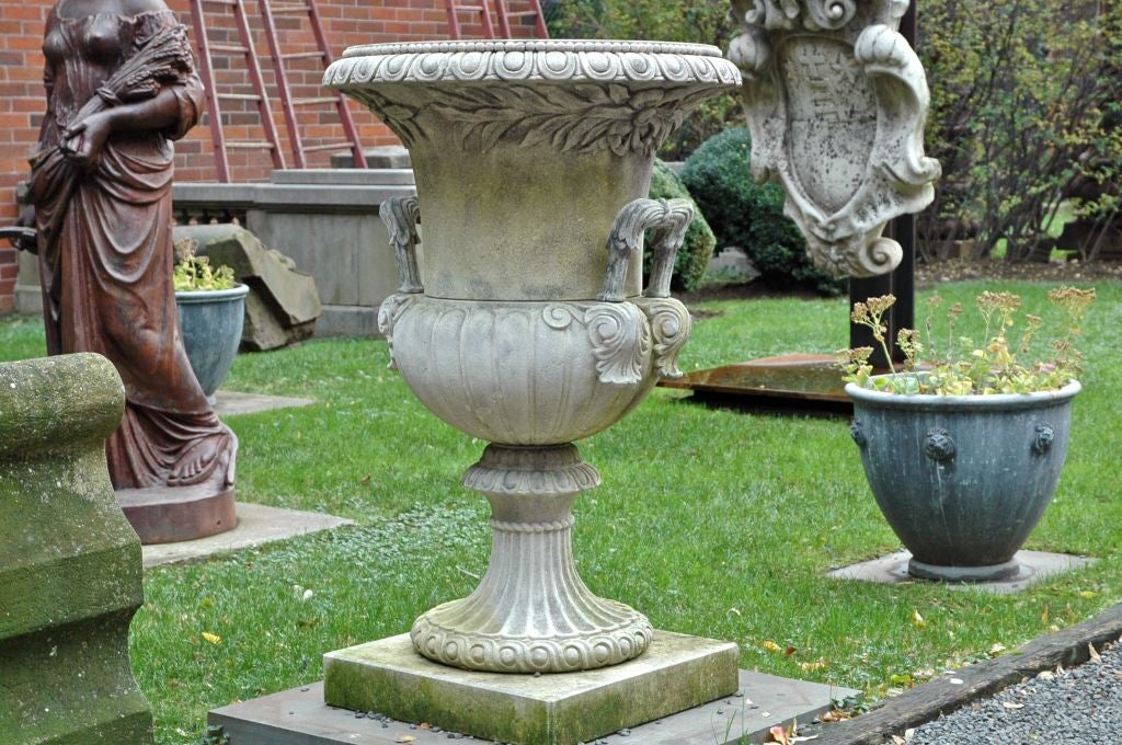 Italian, 20th century Classical campana-form urn with an egg-dart detailed outer lip, handles terminating in acanthus leaves resting on top of a gadrooned urn, with a slender fluted scole and guilloche modeling about the base.  This urn also
