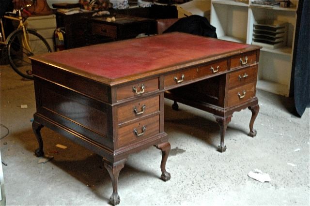 English, turn of the century, mahogany partners desk with tooled leather top and claw feet.  Small loss of the molding on the right side, see image.