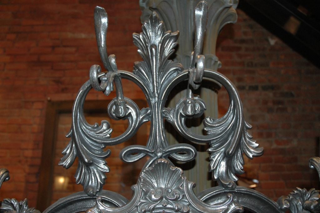American, turn of the century, cast iron hall tree, the design is primarily based on an acanthus leaf relief, replete with and unusual adjustable mirror, six hooks and an umbrella stand (with removable drip tray at the base). Finished in hand
