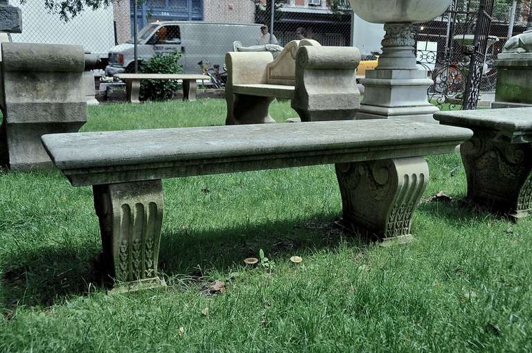 Italian, 20th century, hand carved limestone bench with a classic tapered seat and two scroll supports with a nicely carved garland relief.  