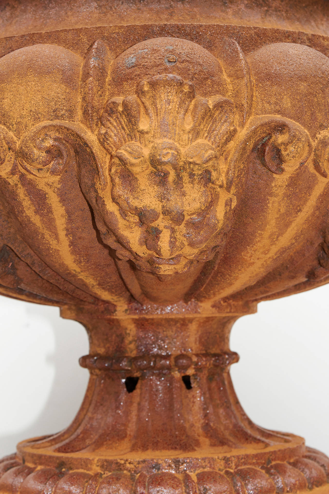 Unusual pair of early cast iron urns by the Ducell foundry in the mid-19th century with the bowl surrounded by faces.

Dimensions: 17 in. diameter.
10 in. opening.