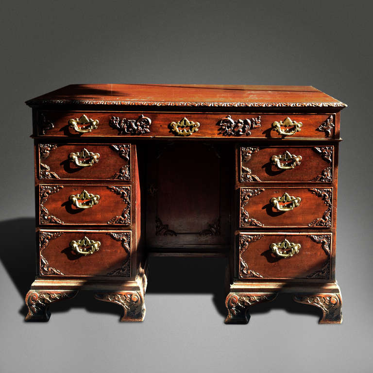 A Small Irish Mahogany Desk With Carved Detail And Brass Handles 