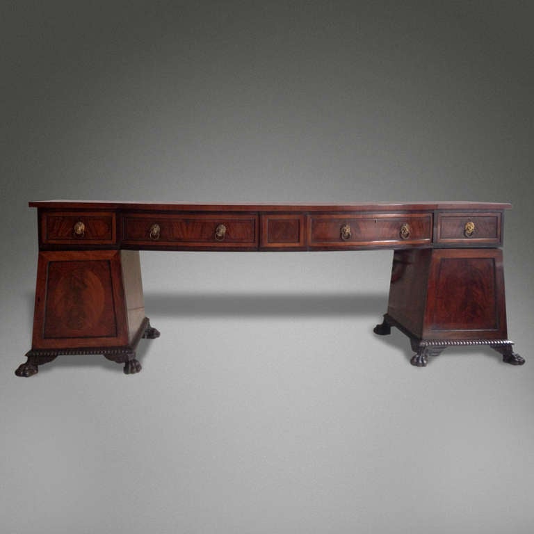 A VERY FINE AND EXCEPTIONALLY LARGE REGENCY SIDEBOARD

In Flame Mahogany with ebony inlay

Having four drawers with finely cast gilded bronze lasko handles above a pair of pile on cabinets one containing a celarette the other with sliding trays