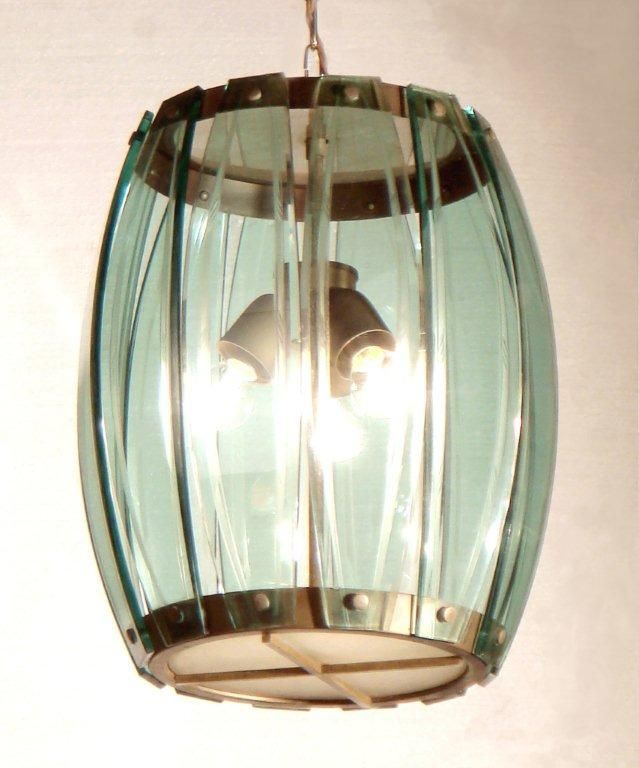 A GLASS HANGING LAMP <br />
<br />
WITH A GILT BRONZE FRAME AND PANELS OF SHAPED AND ETCHED <br />
<br />
GLASS  HAVING CIRCULAR FROSTED PLATES ABOVE AND BELOW<br />
<br />
ENCLOSING THE CLUSTERED THREE LIGHT FITTING