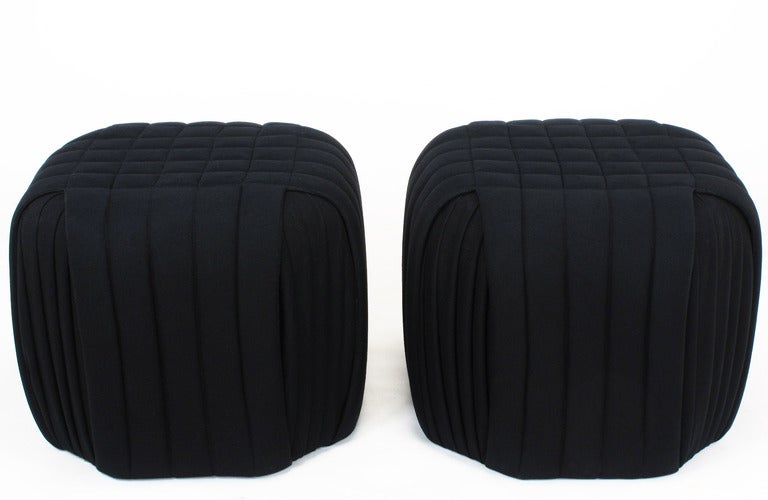 Pair of black wool ottomans with channeled sides,square tufted top, as well as recessed pleated and canted corners. Originally offered by Preview, the modern design division of Hekman Furniture that featured designs by Vladimir Kagan.