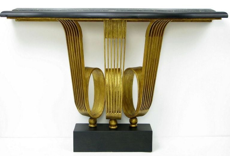 Based upon a 1926 design by Raymond Subes for Emile-Jacques Ruhlmann, as interpreted by Edward Leisner of Murray's Iron Works.

Gilt iron scrolled pedestal, black granite top rests on a solid wood platform lacquered in matte black. Base is matte