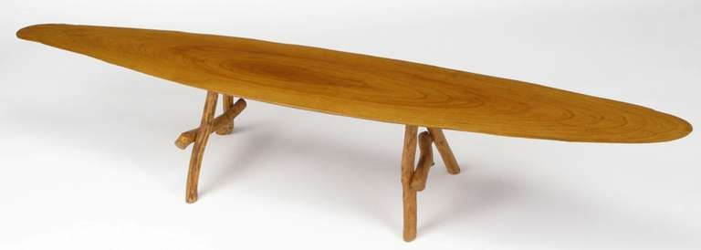 Petite Adirondack style coffee table constructed of natural wood legs and a center cut, live edge wood top.