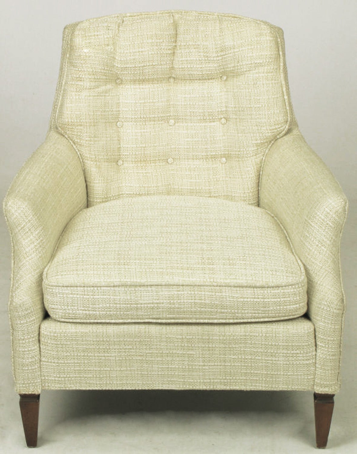 Cream-oatmeal linen upholstered lounge chair with matching ottoman. Button tufted back, loose seat cushion with sculpted arms that splay slightly. Reverse obelisk walnut legs.