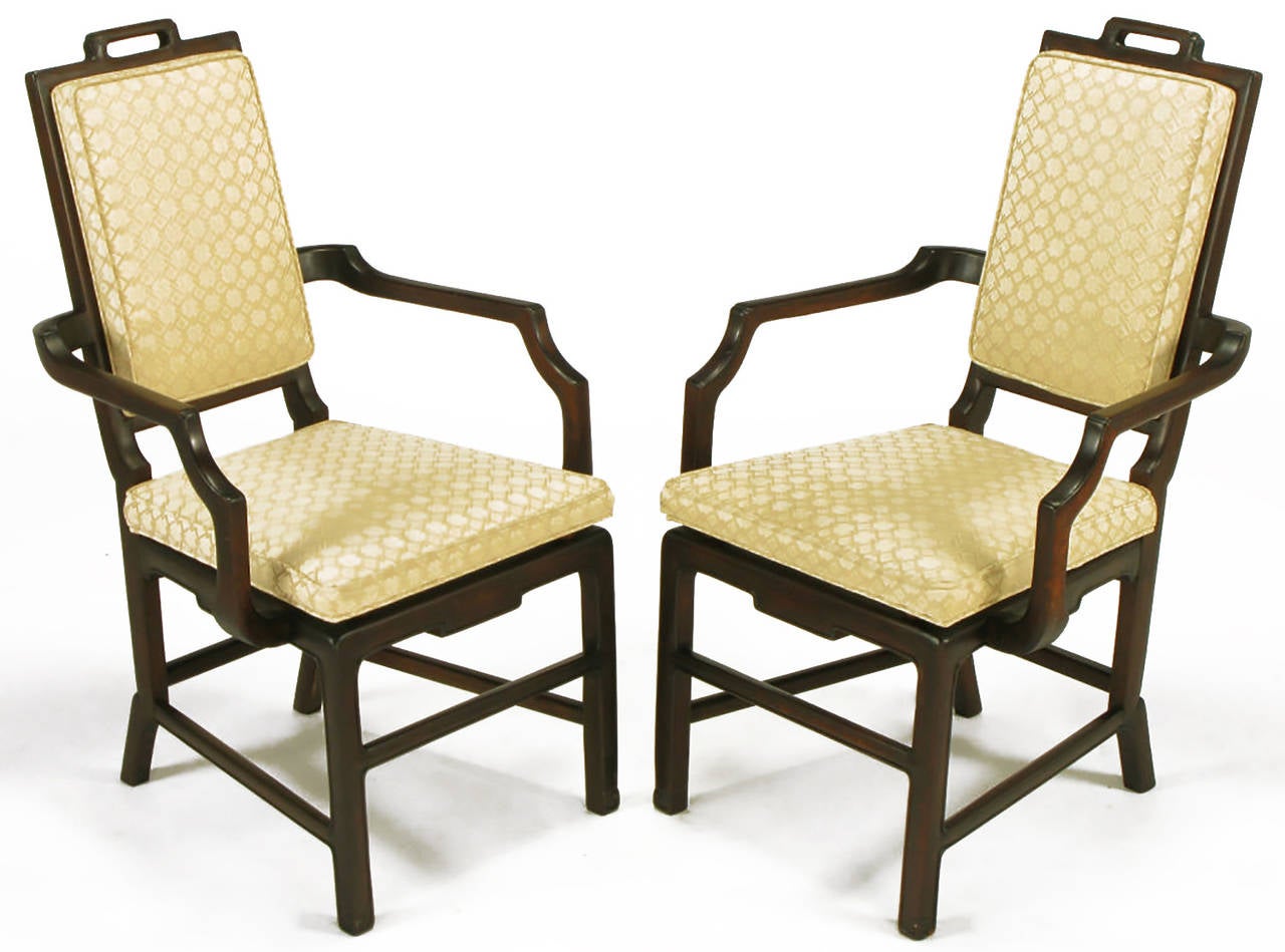 Pair of Asian Modern carved mahogany wood and ivory print silk upholstered armchairs. Wide set arms with floating seat on doweled spacers. Tall backs with top carved wood open handle.
