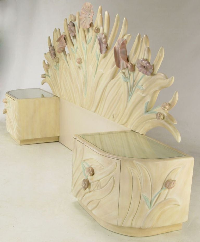 Striking queen headboard with matching glass-topped and attached nightstands, by Phyllis Morris, the Los Angeles furniture designer to the stars. Art nouveau inspired bedroom piece made of carved wood and gesso, with amazing raised floral relief.