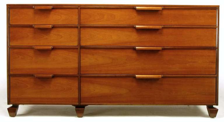 Eight drawer long dresser by Tomlinson, Furniture. An amalgamation of the Danish designs of the period and the simple modern offerings by Paul McCobb and Edward Wormley. Standouts are the six inverse obelisk feet and carved wood waterfall pulls.