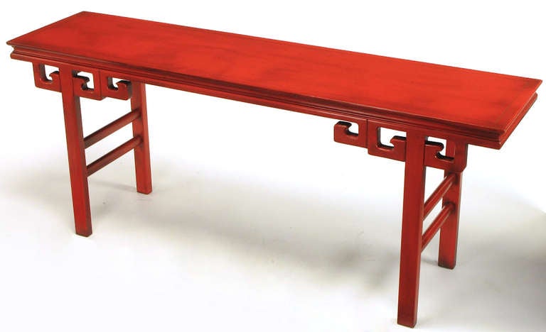 Table d'autel ou console chinoise sculptée et laquée dans le style de James Mont. Pieds en goujon quadrillé avec doubles traverses latérales et triples consoles à clé grecque. Fini sur les deux faces et laqué dans un cinabre vieilli, avec un glaçage