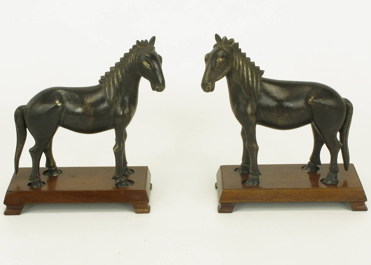 Excellent casting and color perfected by age, bronze Arabian stallions on removable mahogany footed plinths.