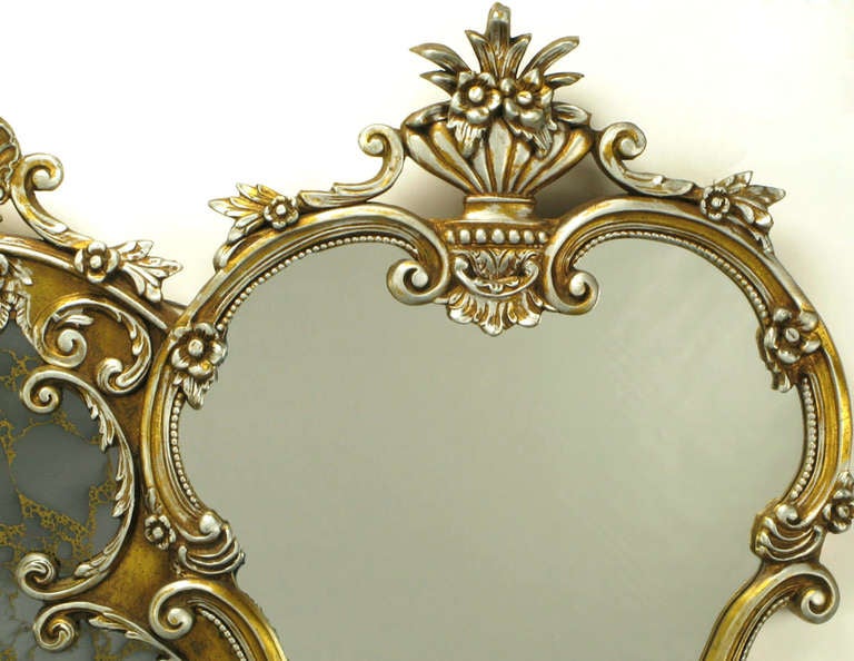 Sensually designed and wonderfully detailed. This gilt and silver washed carved wood and gesso mirror abounds with filigree, shell and foliate styling. An amazing over mantel mirror, or master bath double vanity mirror with a veined Venetian mirror