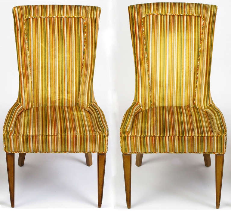 Pair of striped and cut velvet empire style arm chairs with inset seat cushions. Walnut carved and tapered front legs and canted curved back legs. Cut velvet upholstery striped in green, gold, burnt umber, brown and white.