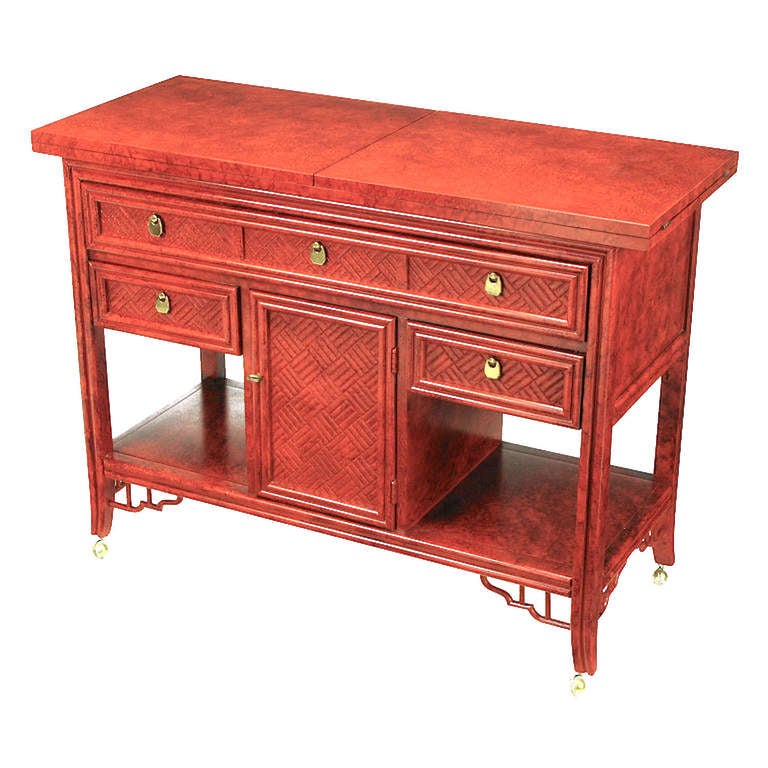 Black glazed cinnabar flip-top bar cart or server with Chinese Chippendale closed fretwork drawer and door fronts. Brass ball casters finish the slight saber curved legs that are detailed with open fretwork brackets. Finished on all four sides, when