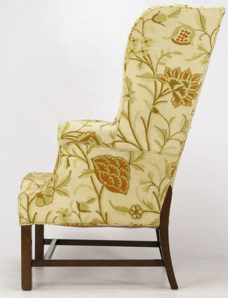 Custom crewel upholstered wing chair by Hickory Chair with sculpted wing sides, unusual walnut rear legs, and button tufted seat cushion. Subtly toned crewel upholstery is in fantastic vintage condition. Four sided walnut stretchers make it heavy