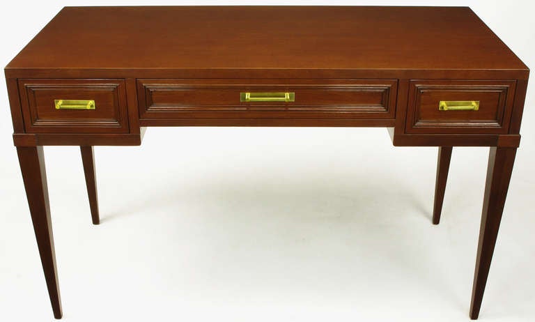 Elegant and modern mahogany three drawer writing table from Fine Arts Furniture, Grand Rapids MI, a venerable name in Grand Rapids furniture history. Twisted Brass bar pulls with simple rectangular escutcheon, framed drawers, and tapered legs.