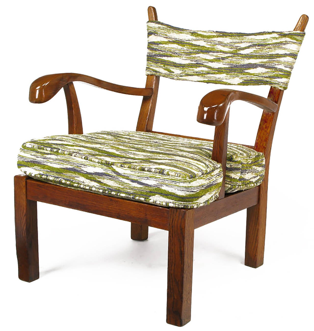 Oak lounge chair upholstered in green, violet blue, and cream fabric, handwoven in the manner of Dorothy Liebes. One-piece strap back supported by tapered risers with carved and exaggerated arms. Chunky squared legs and seat frame.