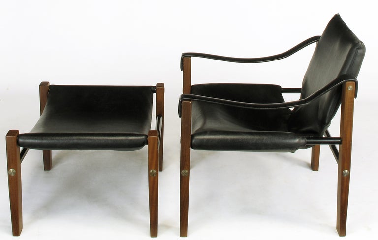 1960′s modernist lounge chair with matching ottoman designed by Maurice Burke for Arkana Furniture. Solid teak wood legs with lacquered steel stretchers and machined large head screws. Upholstered in a heavy black vinyl with form supports inside the