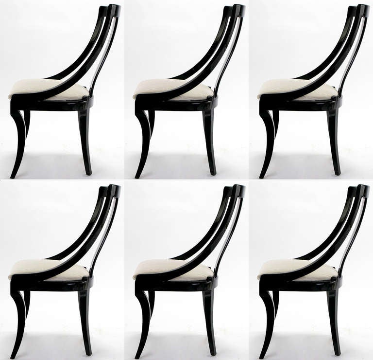 Sculptural curved and open back dining chairs in black lacquer over wood with white silk-like moire upholstery. Saber legged set of six side chairs. Similar in designs by Italian designer Pietro Constantini.