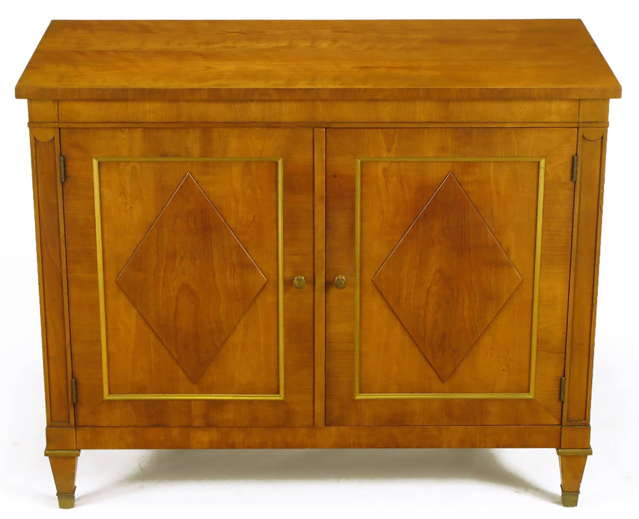 Kindel Furniture figured light walnut Regency two-door cabinet with diamond shaped burl door panels, and parcel gilt detailing. Brass sabots and tapered leg capitals along with brass pulls. Two doors open to reveal a pair of drawers and open lower