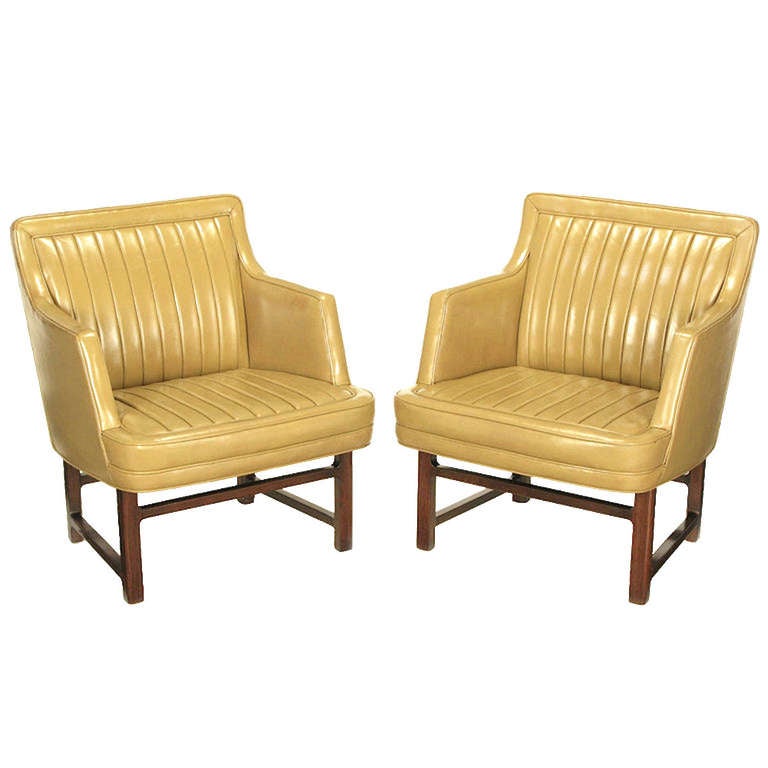Pair of Edward Wormley for Dunbar taupe leather and mahogany arm chairs. Original channeled leather seats and backs with mahogany legs and stretchers. Rare design from Wormley and Dunbar. Seat height 17