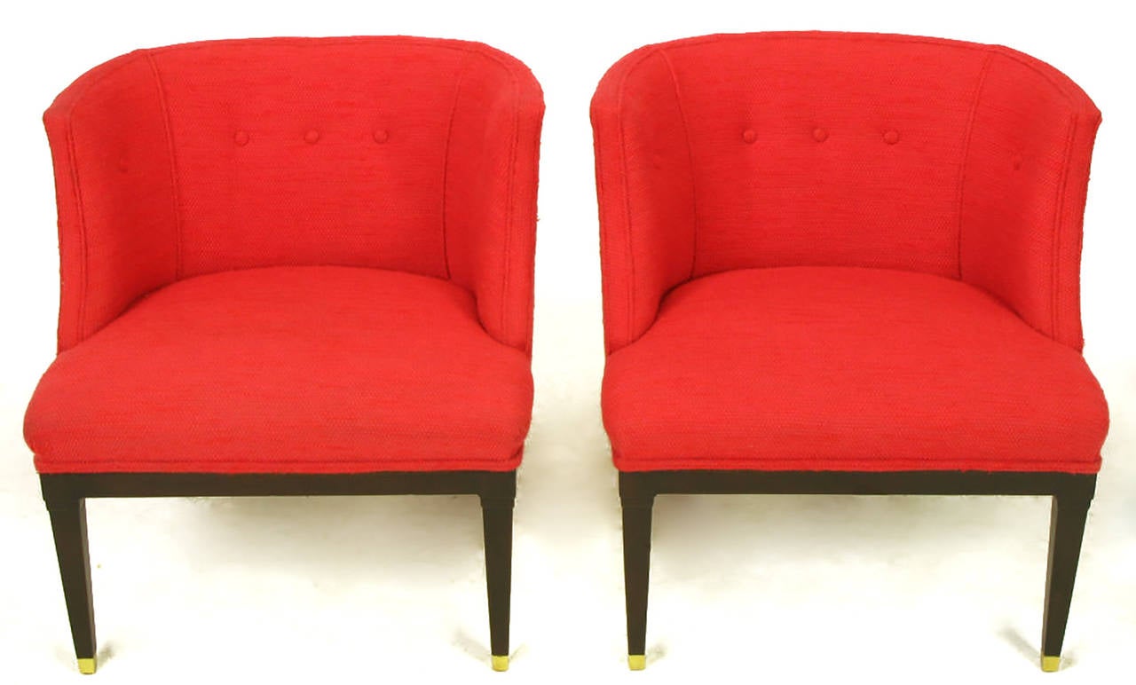 Pair of red wool petite wing chairs with dark stained walnut legs with a half exposed walnut front apron. Front legs have a recessed panel with brass sabots and saber rear legs.